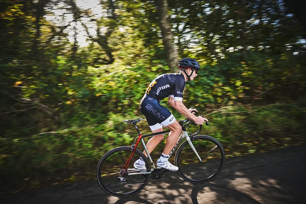 Ciclista treinando em uma subida fazendo máximo de esforço.
