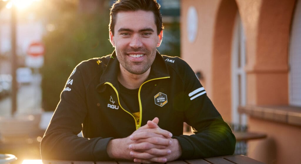 Tom Dumoulin sentado a mesa com um sorriso no rosto.
