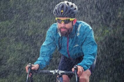 Ciclista amador pedalando na chuva.