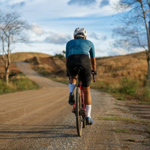 Ciclista treinando em uma estrada de terra com sua bike de gravel.