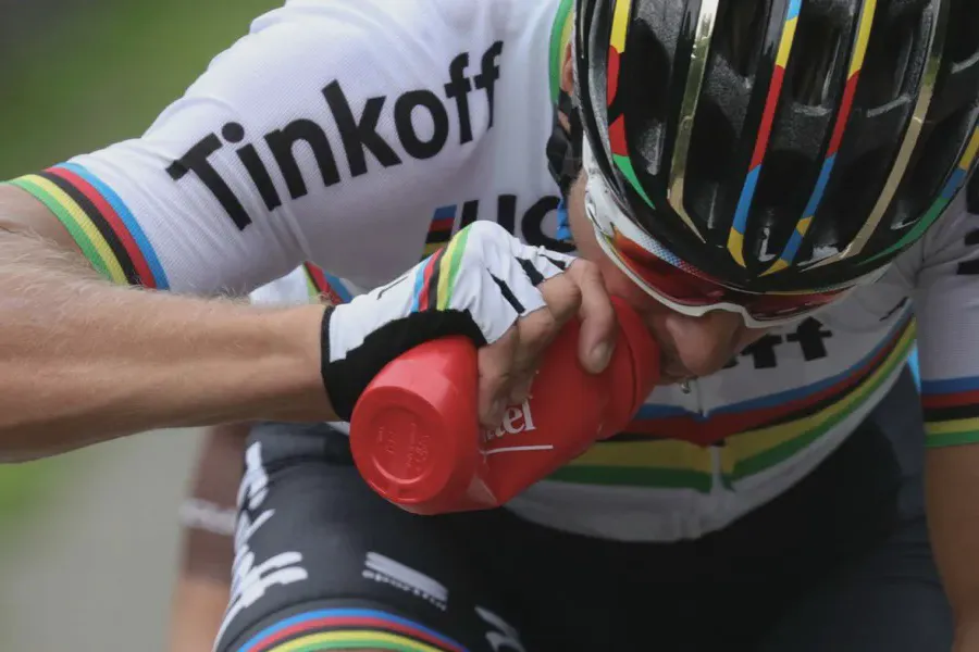 Ciclista profissional se hidratanto durante uma competição.