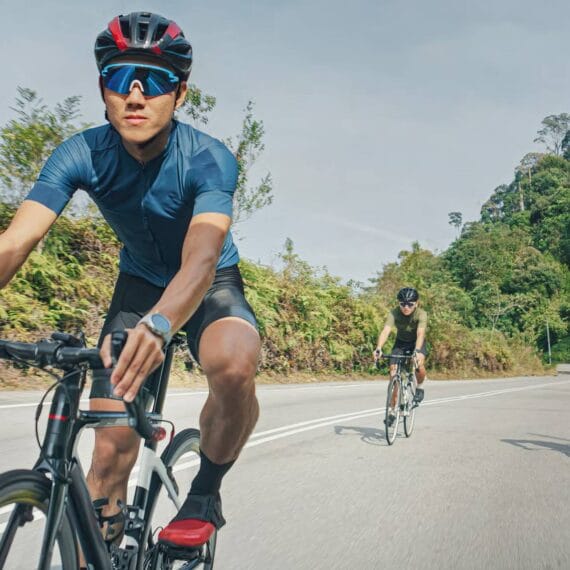 Três ciclistas treinando em uma rodovia totalmente sem carros.