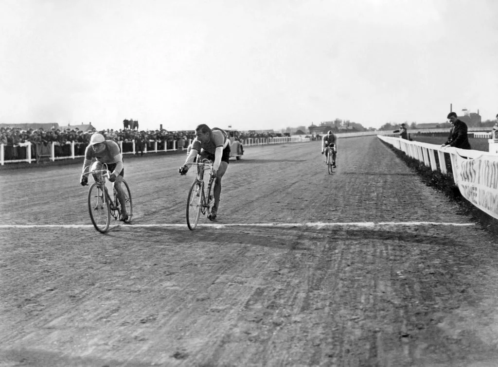 Dois ciclistas disputam roda a roda na chegada da corrida de 1936, quando a Paris-Roubaix terminou em uma pista de corrida de cavalos, assim como havia acontecido no ano anterior. 