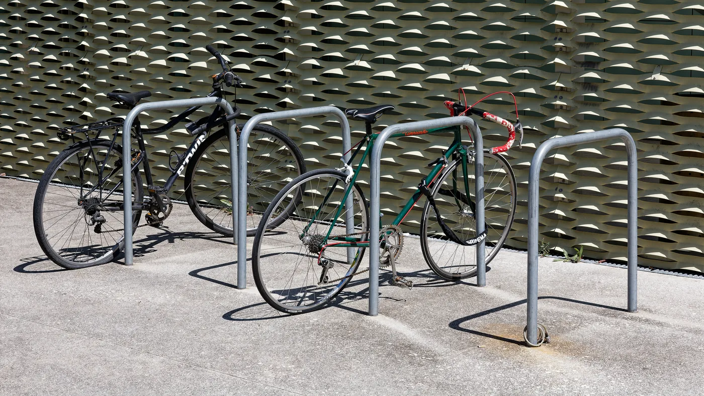 Bicicletas de uso diário estacionadas em paraciclo de rua