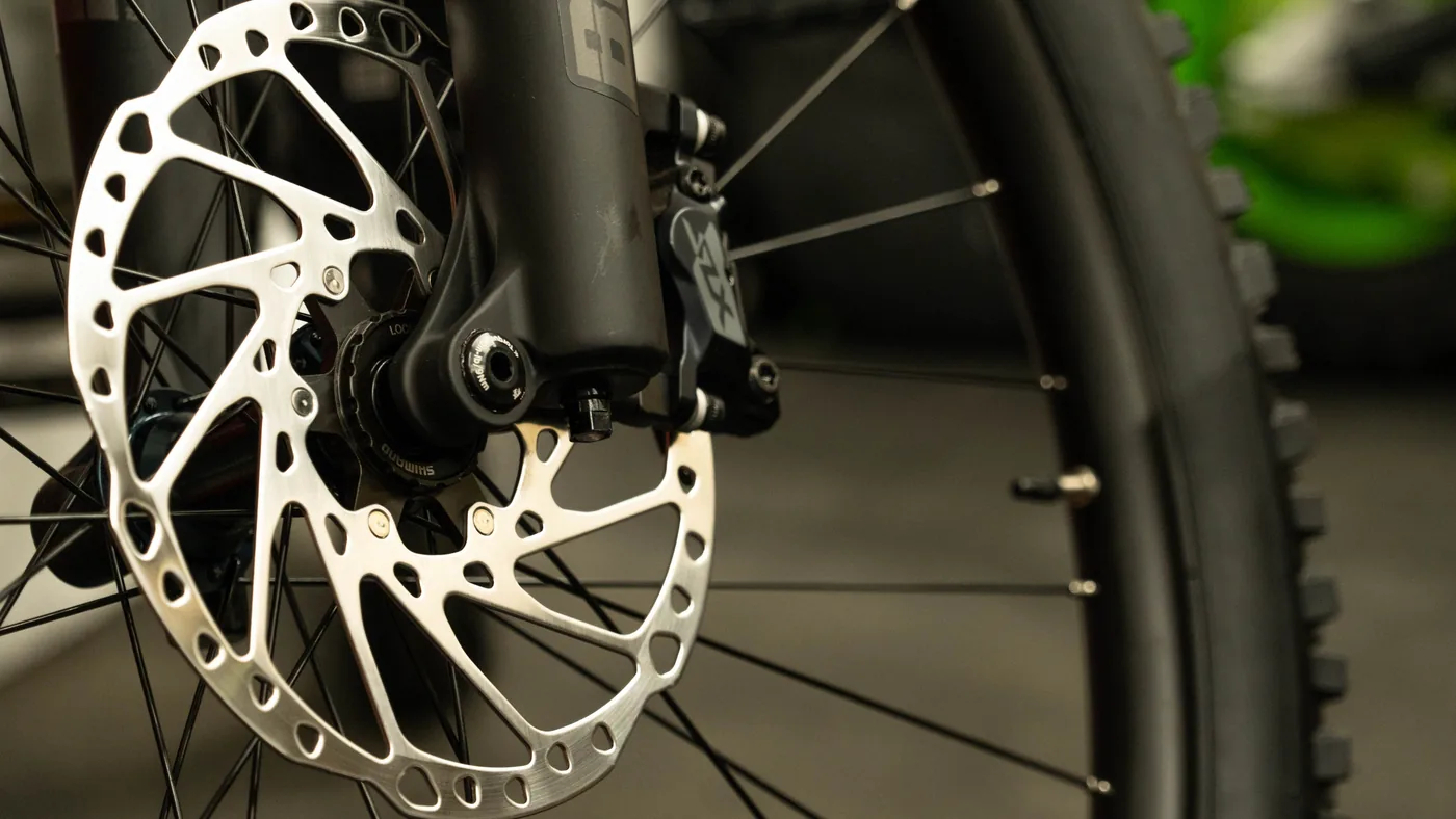 Detalhe de freio a disco de bicicleta, com rotor e pinça visíveis