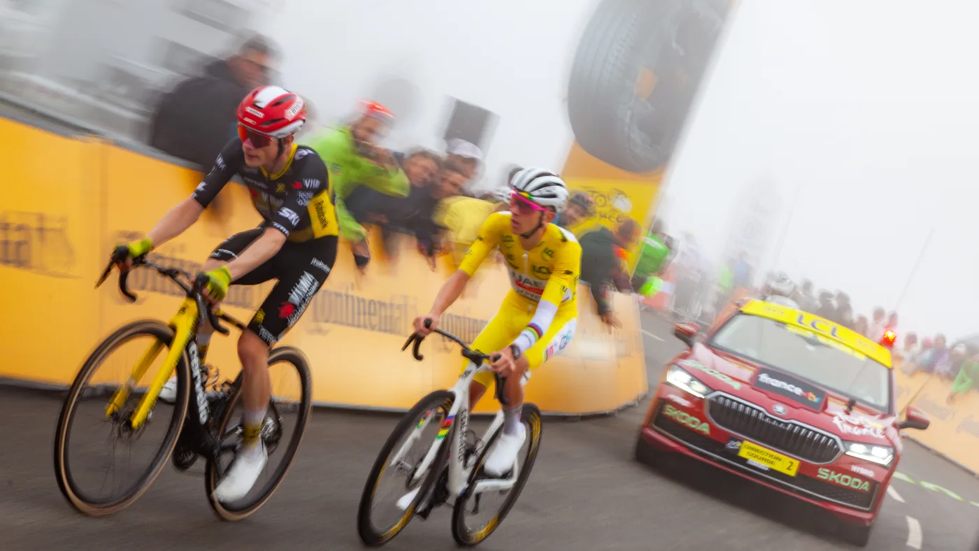 Jonas Vingegaard e Tadej Pogačar de amarelo lado a lado na neblina, perto da chegada da etapa 14 do Tour de France 2025
