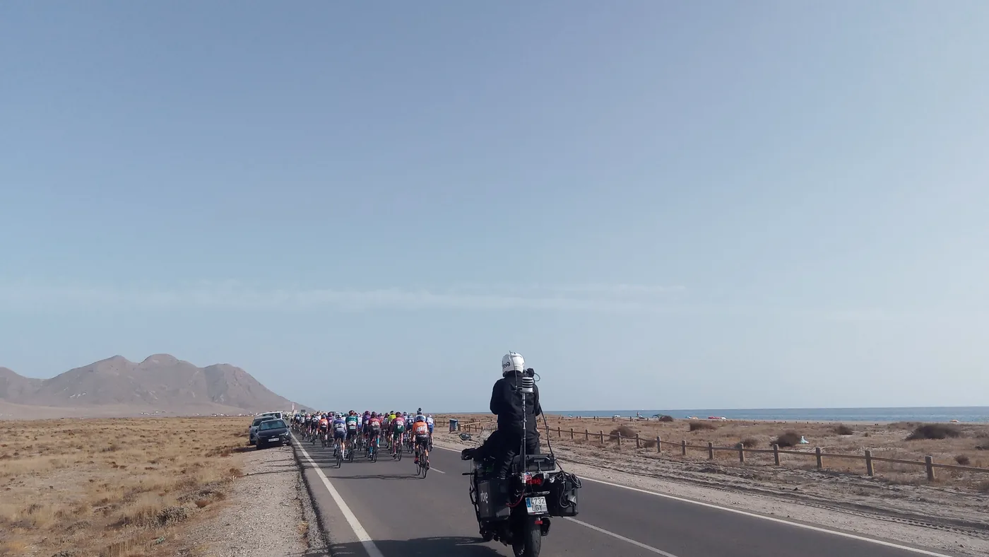 Moto da organização abre caminho para o pelotão numa estrada do Cabo de Gata, na etapa 11 da Vuelta 2022