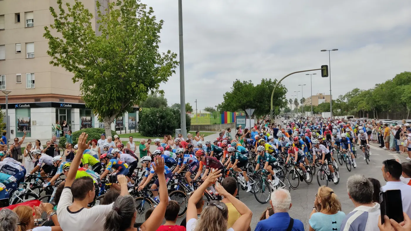 Pelotão da Vuelta a España 2024 passa entre a torcida numa avenida de Jerez de la Frontera, na largada da etapa 6