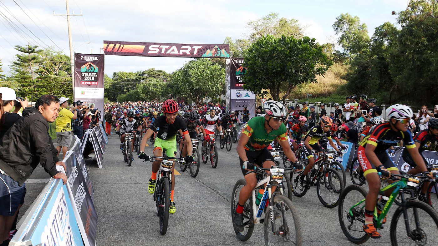 Pelotão de ciclistas larga em prova de mountain bike, lado a lado na linha de largada