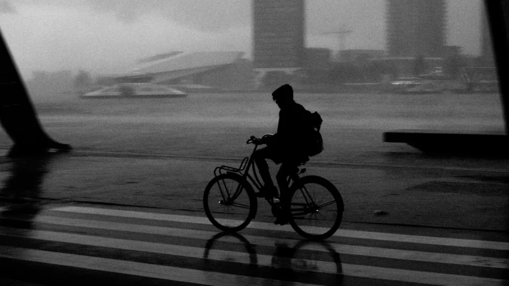 Ciclista pedala sob chuva intensa.
