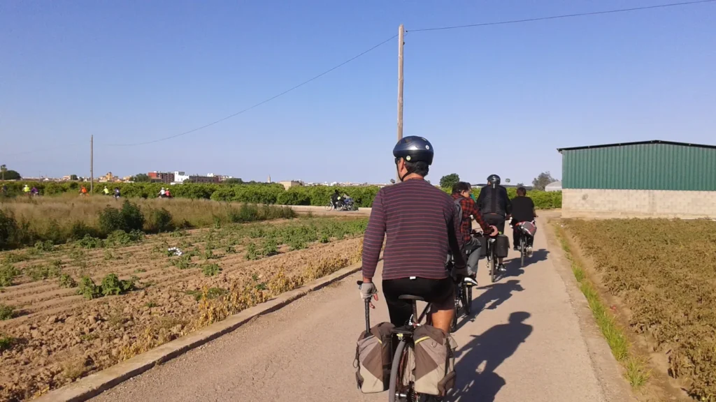 Ciclistas pedalam em grupo por estrada rural