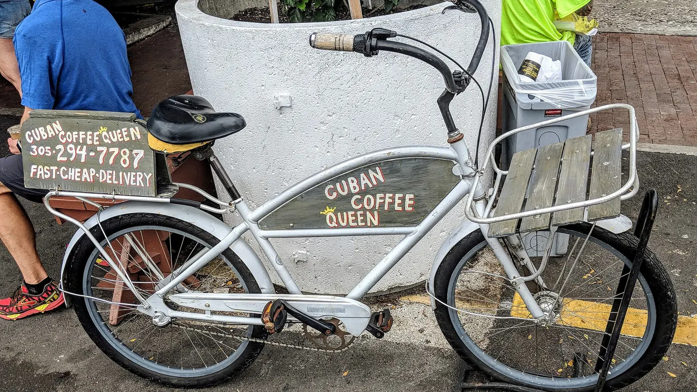 Bicicleta de entrega a pedal com bagageiro de madeira e placa de delivery pintada à mão, do tipo que dispensa o teste de categoria