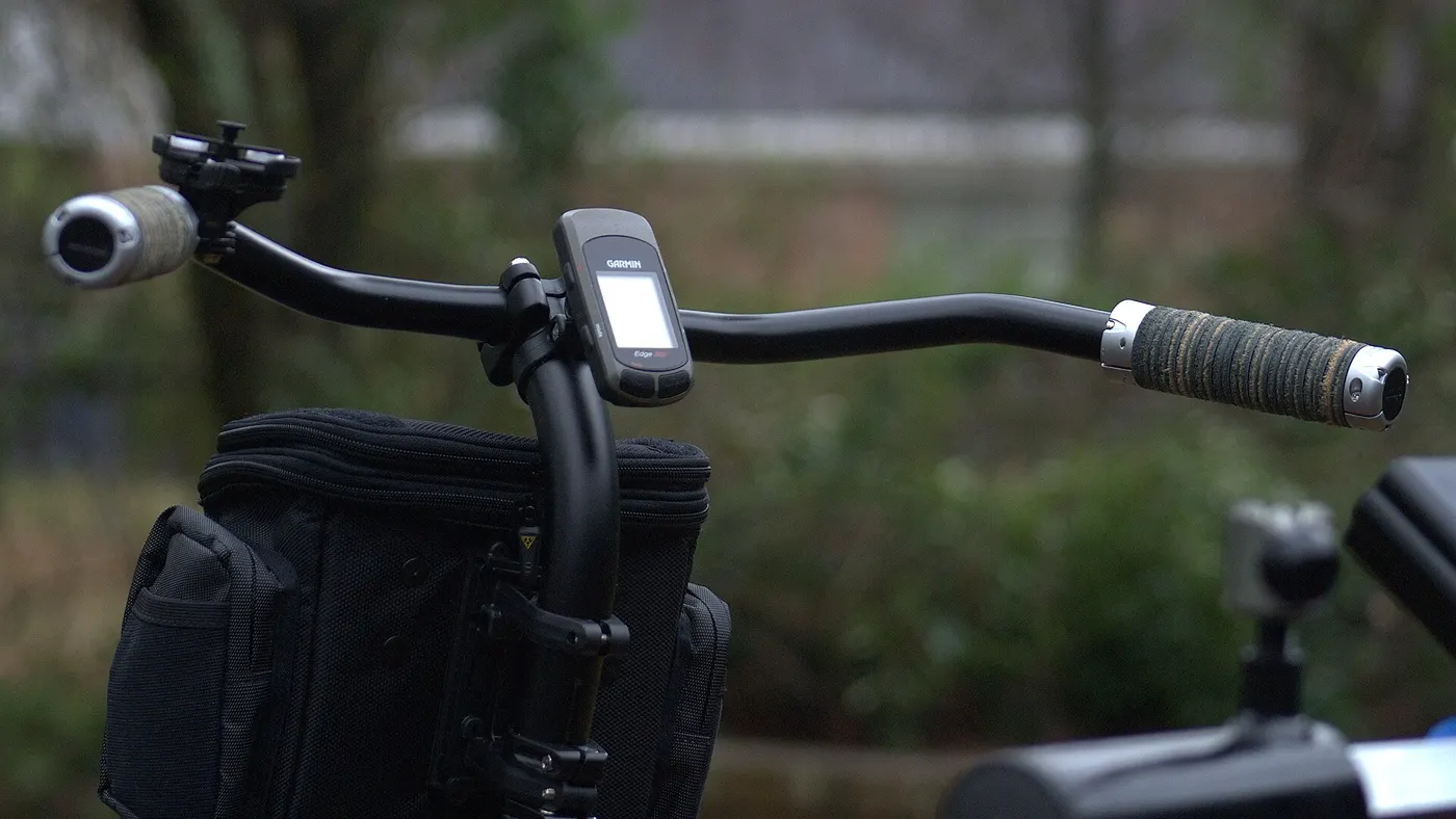 Ciclocomputador GPS montado no centro do guidão de uma bicicleta, cumprindo o papel de indicador de velocidade