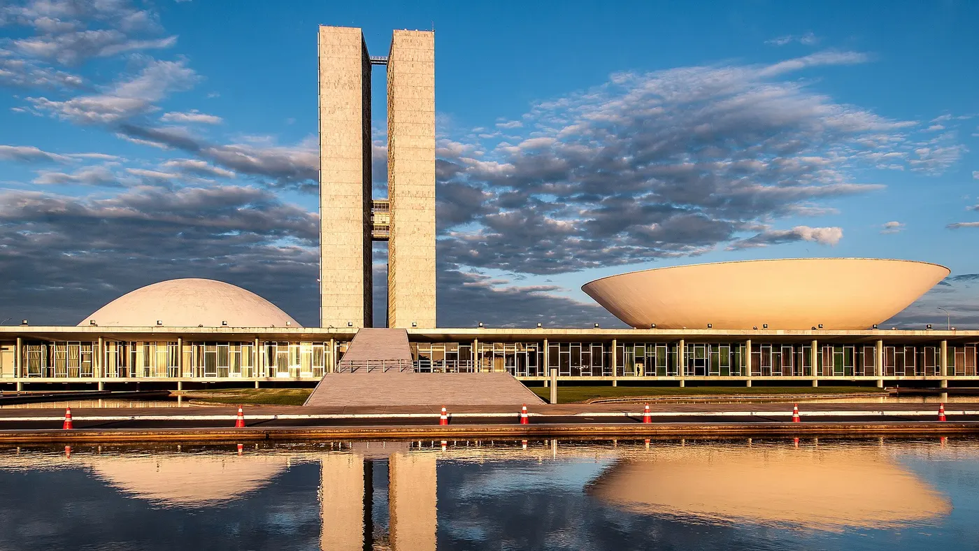 Edifício do Congresso Nacional em Brasília, com as torres gêmeas e as cúpulas refletidas no espelho d'água