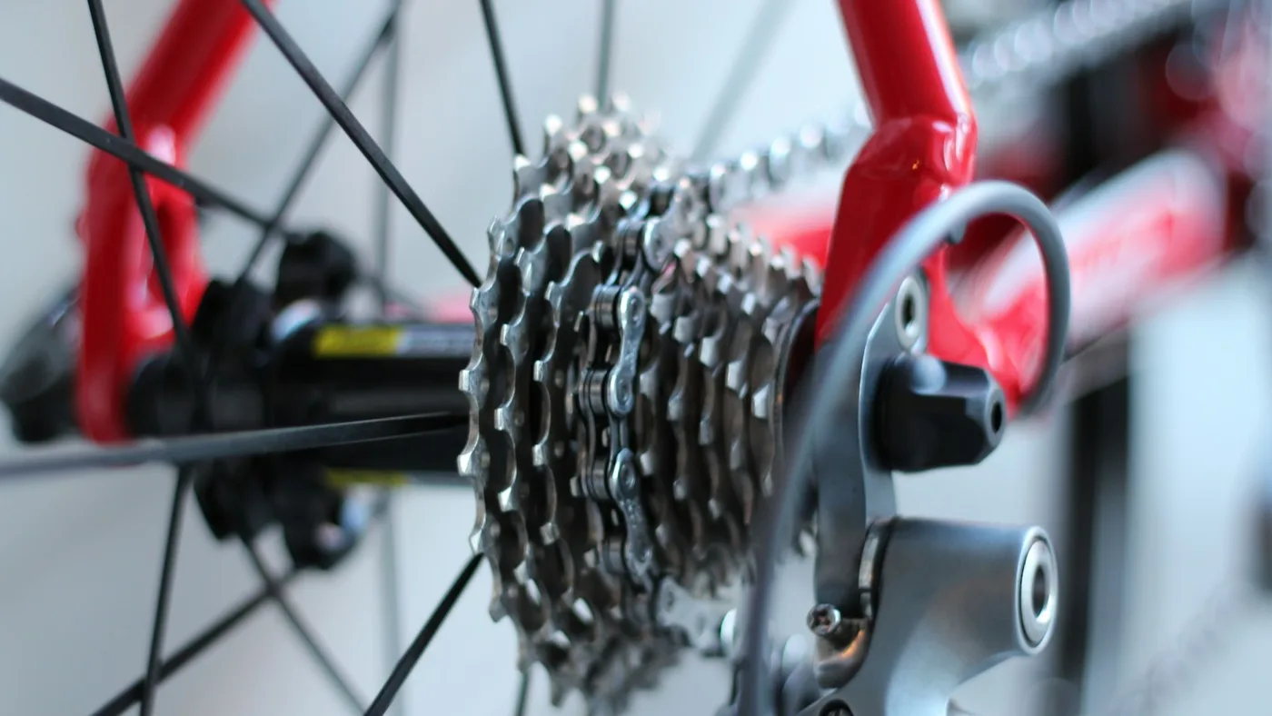 Foto em close de pessoa limpando a bicicleta durante manutenção